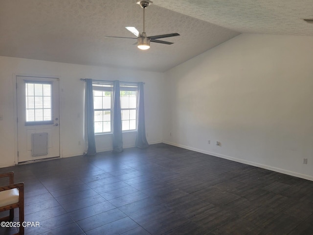 unfurnished room with ceiling fan, baseboards, vaulted ceiling, and a textured ceiling