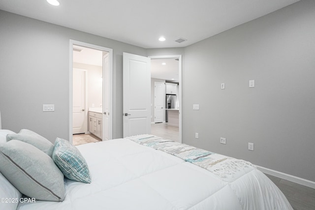 bedroom with recessed lighting, visible vents, light wood-style floors, baseboards, and stainless steel refrigerator with ice dispenser