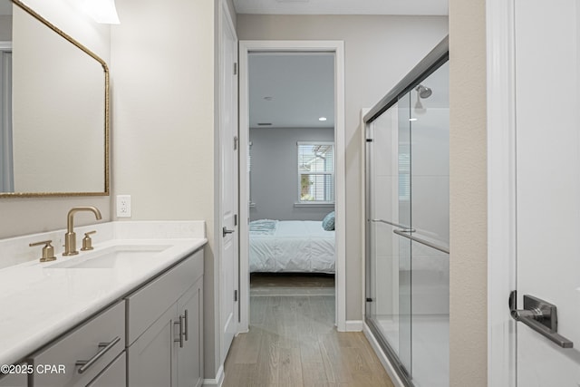 full bathroom with a shower stall, connected bathroom, vanity, and wood finished floors