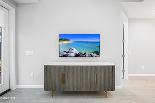 living area with baseboards and wood finished floors