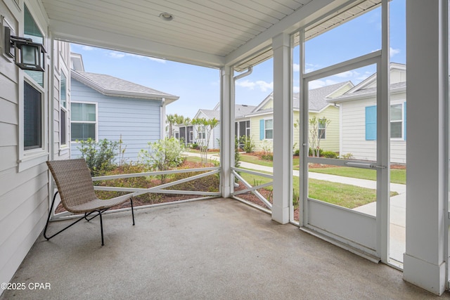 unfurnished sunroom featuring a wealth of natural light and a residential view