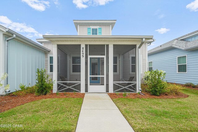 doorway to property with a yard and board and batten siding