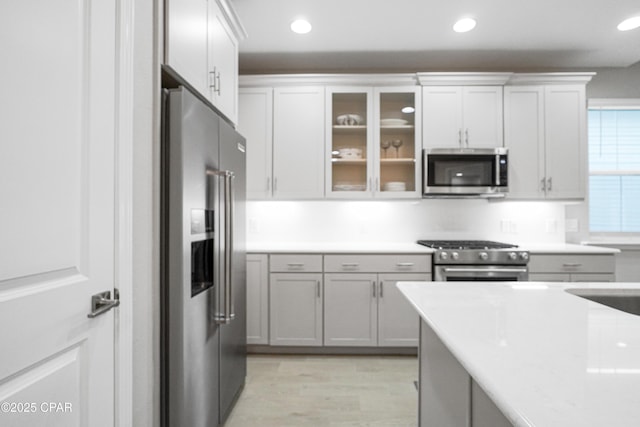 kitchen featuring glass insert cabinets, recessed lighting, appliances with stainless steel finishes, and light countertops