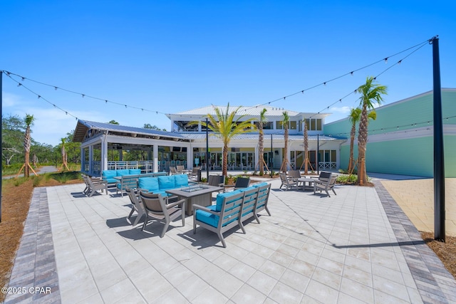 view of patio with an outdoor living space with a fire pit