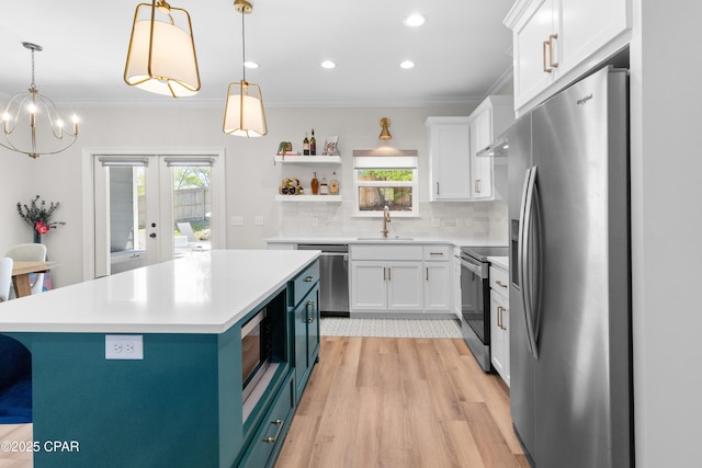1106 E 3rd St, Panama City, FL 32401 - kitchen with light wood-style flooring, a healthy amount of sunlight, open shelves, white cabinets, and appliances with stainless steel finishes