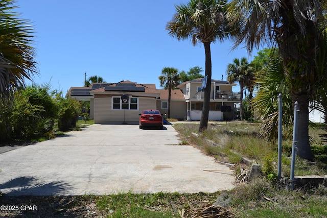 exterior space featuring roof mounted solar panels and concrete driveway