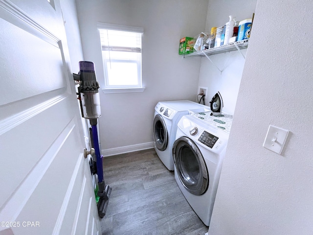 laundry room featuring laundry area, baseboards, washing machine and dryer, and wood finished floors