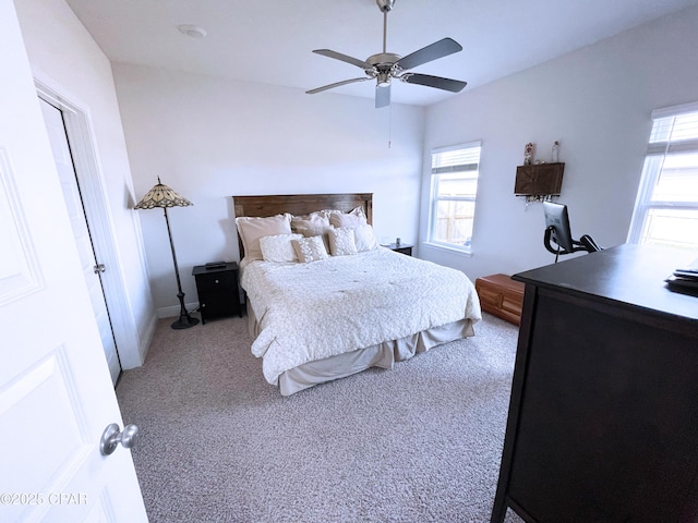bedroom with multiple windows, light carpet, and a ceiling fan