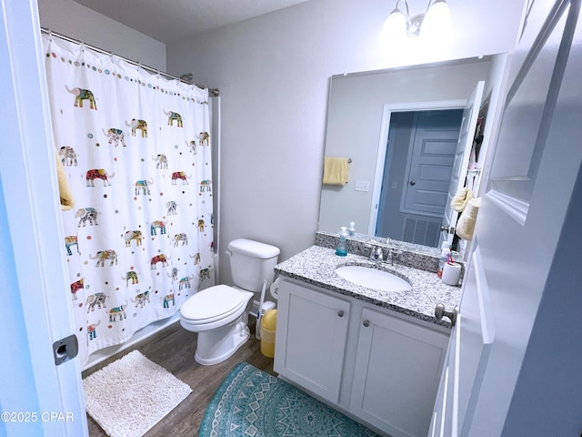 full bath featuring a shower with shower curtain, toilet, wood finished floors, and vanity