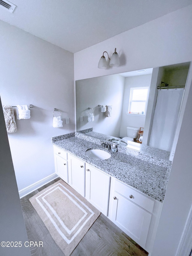 bathroom featuring vanity, toilet, a shower with shower curtain, wood finished floors, and visible vents