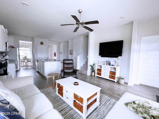 living area featuring baseboards, ceiling fan, stairway, recessed lighting, and dark wood finished floors
