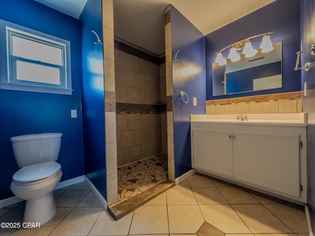 bathroom featuring vanity, baseboards, tile patterned flooring, toilet, and a walk in shower