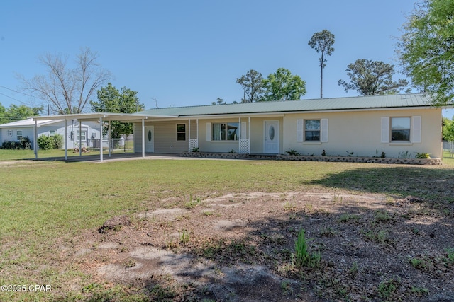 single story home with metal roof, an attached carport, and a front lawn