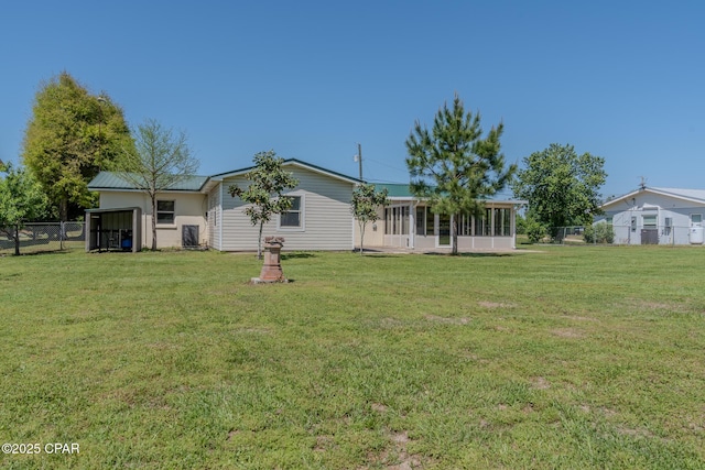exterior space with a sunroom, a yard, and fence