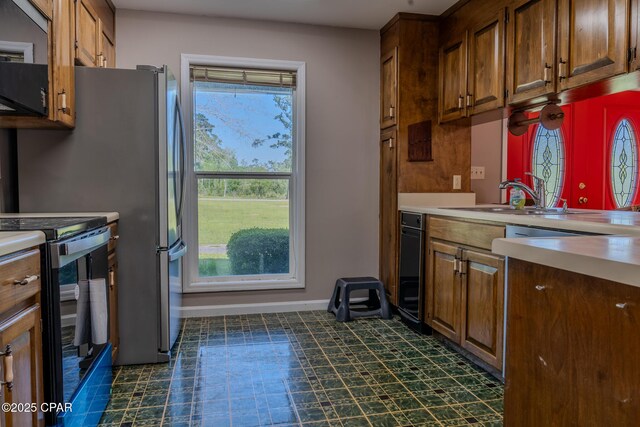 2613 Indian Springs Rd, Marianna, FL 32446 - kitchen with a sink, light countertops, electric stove, brown cabinets, and baseboards