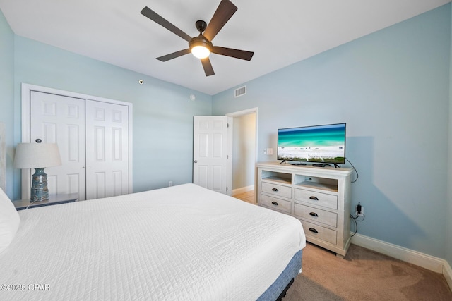 bedroom featuring a closet, baseboards, light carpet, and ceiling fan