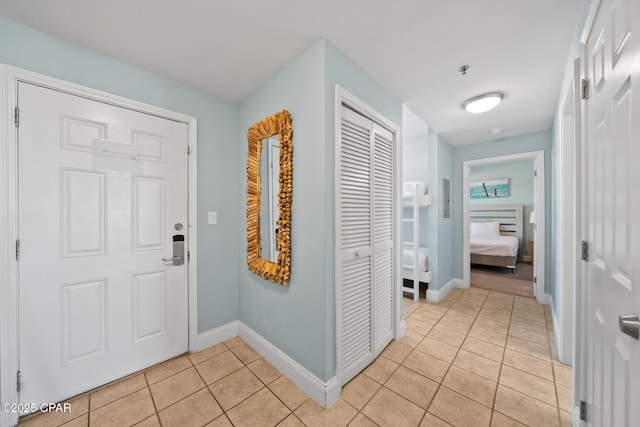 foyer featuring light tile patterned flooring and baseboards