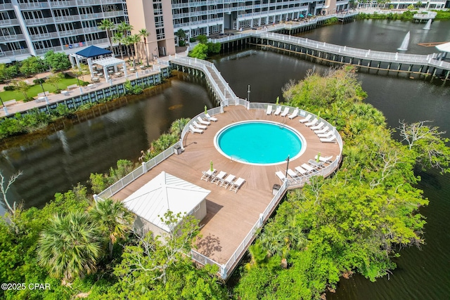 drone / aerial view of a nearby body of water and a pool area