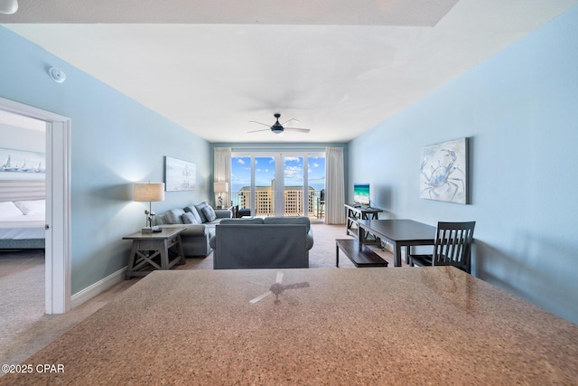 dining room with carpet flooring, a ceiling fan, and baseboards