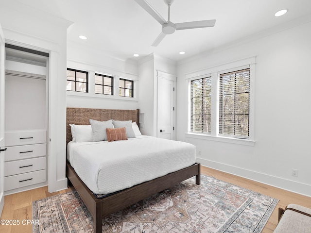 bedroom featuring light wood-style flooring, baseboards, and multiple windows