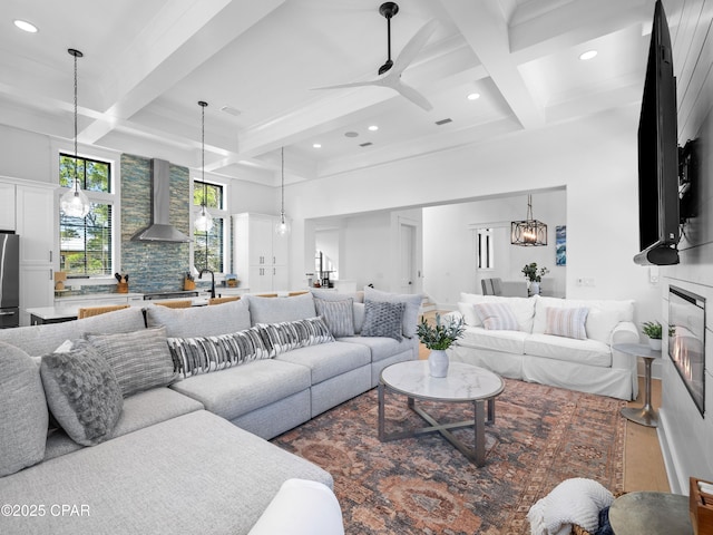 living room with coffered ceiling, a high ceiling, beamed ceiling, and recessed lighting