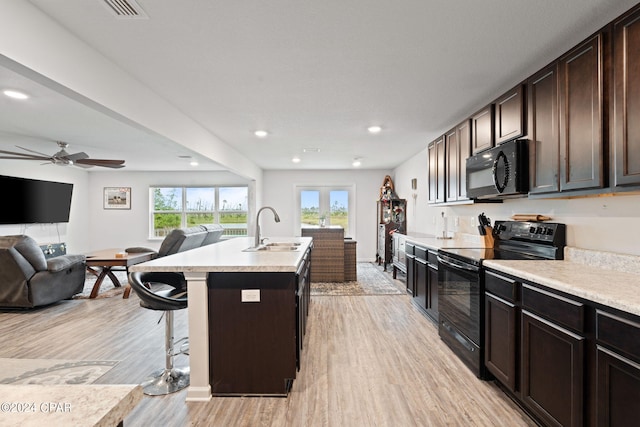 3946 Whitehead Blvd, Panama City, FL 32404 - kitchen featuring light wood-style flooring, a sink, open floor plan, light countertops, and black appliances