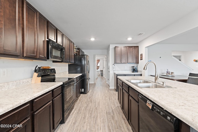 3946 Whitehead Blvd, Panama City, FL 32404 - kitchen with light wood-type flooring, light countertops, a sink, and black appliances