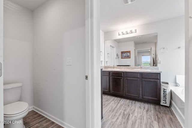 3946 Whitehead Blvd, Panama City, FL 32404 - bathroom featuring wood finished floors, a bath, double vanity, baseboards, and toilet