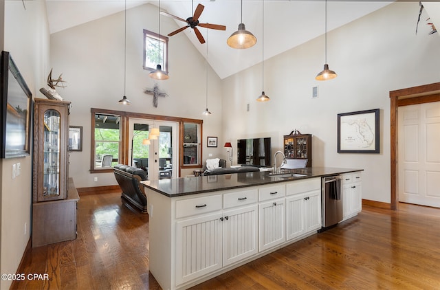 kitchen with high vaulted ceiling, a ceiling fan, open floor plan, and a sink