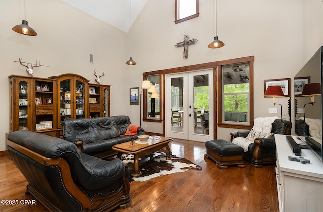 living room featuring wood finished floors, visible vents, high vaulted ceiling, and french doors