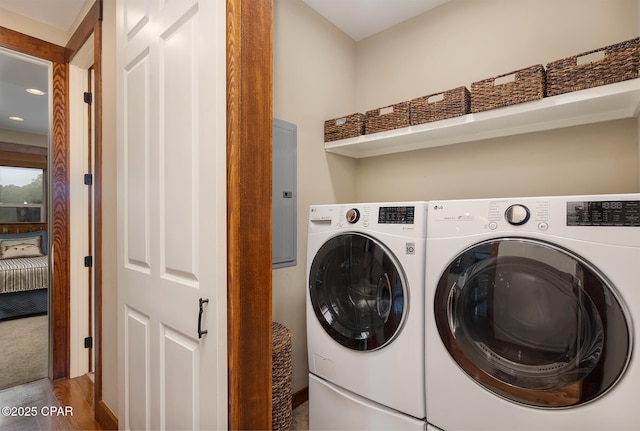 clothes washing area featuring separate washer and dryer, wood finished floors, and laundry area