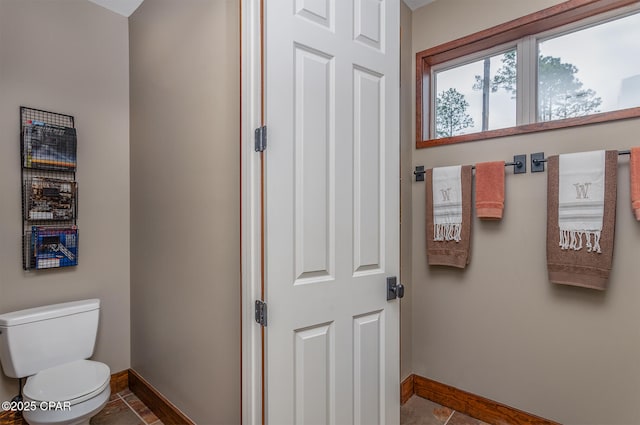 bathroom with tile patterned floors, baseboards, and toilet