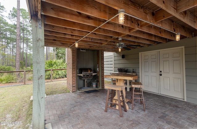 view of patio featuring a grill and fence
