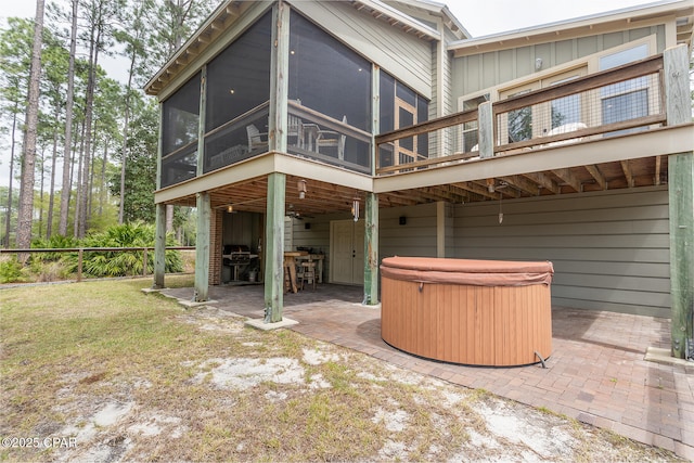 rear view of house with a patio area, a sunroom, a hot tub, and fence
