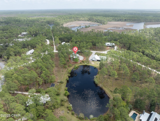 drone / aerial view with a wooded view and a water view