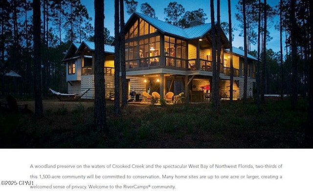 back of house featuring a sunroom and metal roof