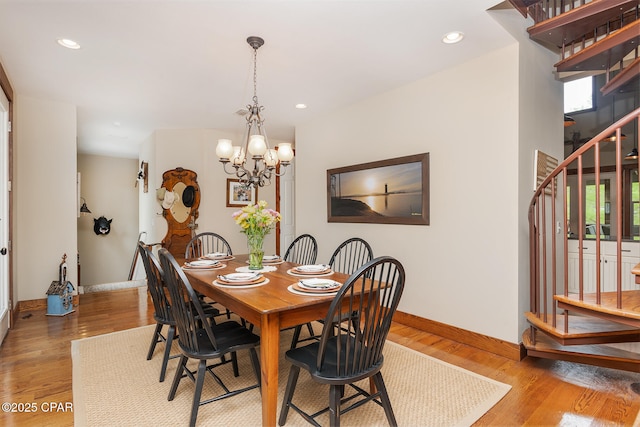dining space with stairs, a chandelier, light wood-type flooring, baseboards, and recessed lighting