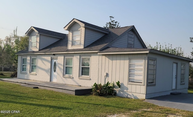 exterior space featuring a yard, board and batten siding, and a shingled roof