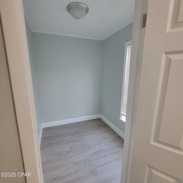 unfurnished room with plenty of natural light, wood finished floors, baseboards, and ornamental molding