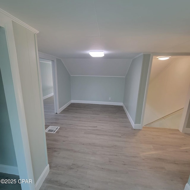 bonus room featuring wood finished floors, baseboards, vaulted ceiling, and visible vents