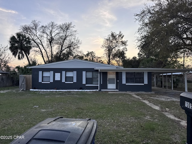 ranch-style home with a front yard and a carport