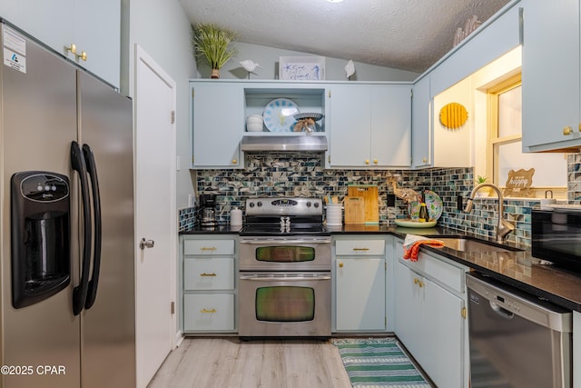 kitchen featuring stainless steel appliances, a sink, and dark countertops