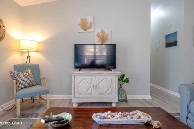 living area with baseboards and wood finished floors