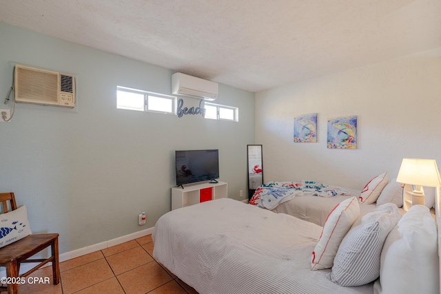 bedroom featuring baseboards, a wall mounted AC, tile patterned flooring, and a wall unit AC