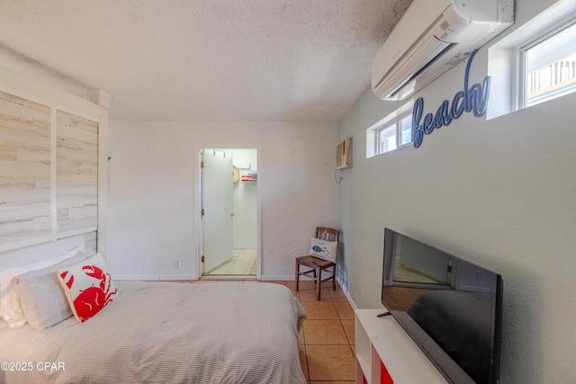 tiled bedroom featuring multiple windows, a wall mounted AC, and a textured ceiling