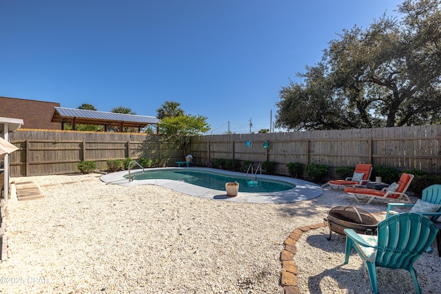 view of pool with a patio area, a fenced backyard, a fire pit, and a fenced in pool