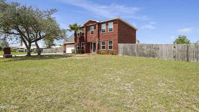 rear view of property featuring brick siding, a lawn, an attached garage, and fence