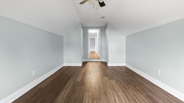 bonus room featuring dark wood-style flooring, ceiling fan, visible vents, vaulted ceiling, and baseboards