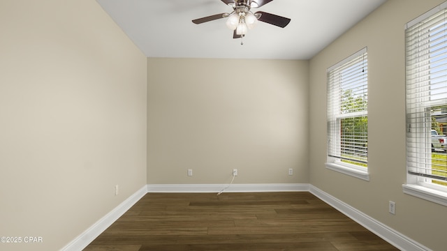 spare room with a wealth of natural light, dark wood-style floors, and baseboards