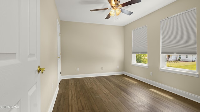 spare room with ceiling fan, dark wood finished floors, and baseboards